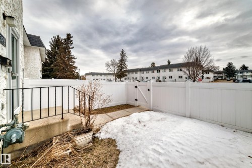 The property features a private fenced yard with a gate, offering a secluded outdoor space - 11393 22 Avenue, Edmonton, AB - Outdoor