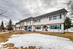 The property features a multi-unit structure with a dark roof and white exterior, accented by blue window shutters - 