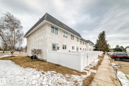 The property features a textured white exterior and a dark sloped roof - 11393 22 Avenue, Edmonton, AB - Outdoor