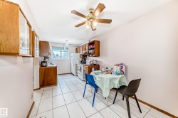 Kitchen area featuring tile flooring, wooden cabinetry, and a ceiling fan - 