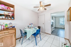 This dining area features white tiled flooring and a ceiling fan with integrated lighting - 
