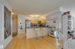 The property features an open-concept living area with light hardwood floors - 