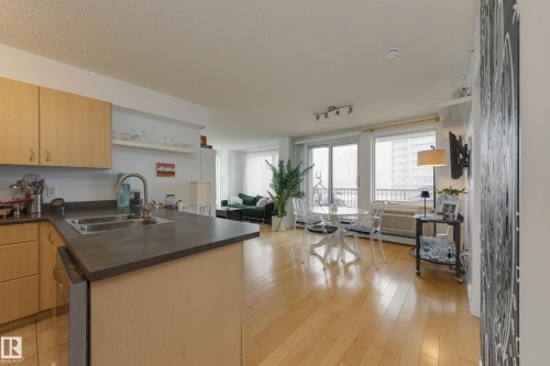 The property features an open-plan kitchen and living area with hardwood flooring - 1007 10180 104 Street, Edmonton, AB - Indoor Photo Showing Kitchen