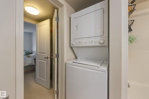 Convenient in-unit laundry area featuring a white stackable washer and dryer - 1007 10180 104 Street, Edmonton, AB - Indoor Photo Showing Laundry Room