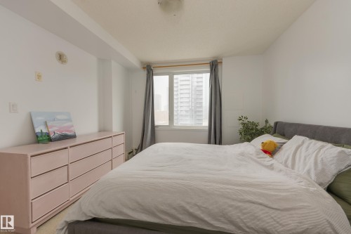 This room features a window with grey curtains, allowing natural light to enter the space - 1007 10180 104 Street, Edmonton, AB - Indoor Photo Showing Bedroom
