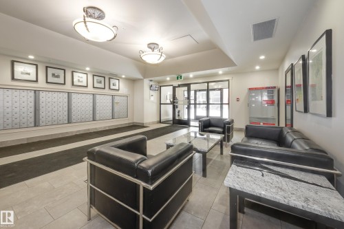 The property features a lobby area with tiled flooring, contemporary ceiling light fixtures, and a wall of mailboxes - 1007 10180 104 Street, Edmonton, AB - Indoor Photo Showing Other Room