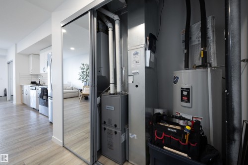 Utility closet featuring a water heater and furnace, conveniently located within the property - 101 860 Secord Blvd, Edmonton, AB - Indoor Photo Showing Other Room