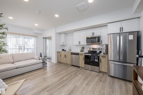The property features an open-concept living area and stainless steel appliances! - 101 860 Secord Blvd, Edmonton, AB - Indoor Photo Showing Kitchen With Stainless Steel Kitchen