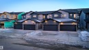 The property features a contemporary exterior with grey siding and dark trim, accented by stone pillars - 7694 174A Avenue, Edmonton, AB  - Outdoor With Facade 