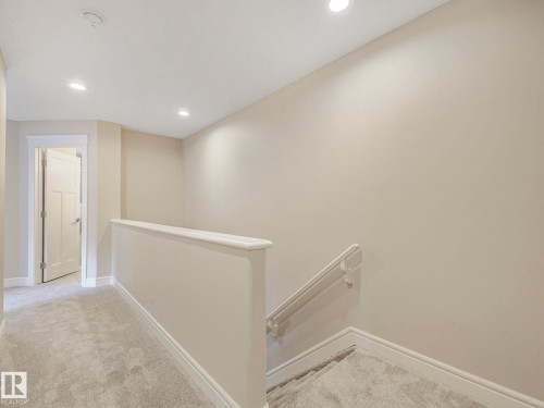 The property features recessed lighting, light-colored walls, and carpeting throughout - 2 10319 120 Street, Edmonton, AB - Indoor Photo Showing Other Room