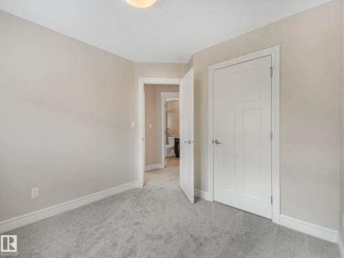 This room features light grey carpeting, neutral painted walls, and white trim - 2 10319 120 Street, Edmonton, AB - Indoor Photo Showing Other Room