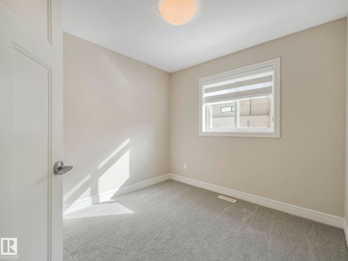 Well-lit room with neutral wall colors and light grey carpet - 2 10319 120 Street, Edmonton, AB - Indoor Photo Showing Other Room