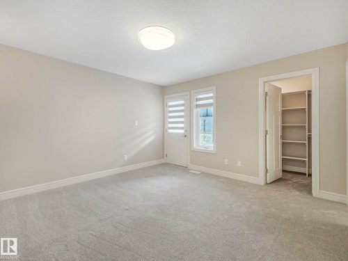 This room features soft gray carpeting, light-colored walls, and a ceiling-mounted light fixture - 2 10319 120 Street, Edmonton, AB - Indoor Photo Showing Other Room