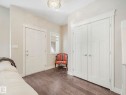 Entryway featuring dark hardwood flooring, a white paneled door, and a decorative light fixture - 2 10319 120 Street, Edmonton, AB  - Indoor 