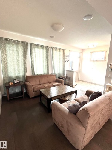 The property features dark hardwood flooring and ceiling-mounted light fixtures - 16464 15 Avenue, Edmonton, AB - Indoor Photo Showing Living Room