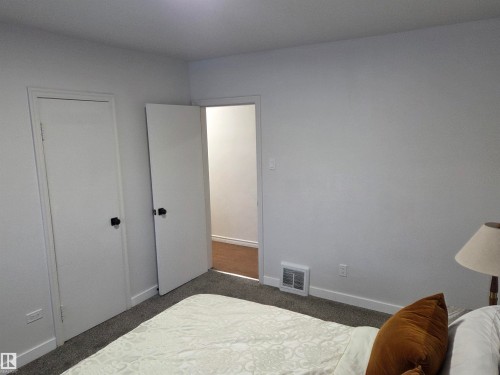 Bedroom featuring baseboards and dark carpet - 13023 Sherbrooke Avenue, Edmonton, AB - Indoor Photo Showing Bedroom