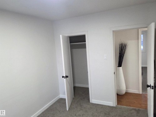Unfurnished bedroom featuring carpet floors and a walk in closet - 13023 Sherbrooke Avenue, Edmonton, AB - Indoor