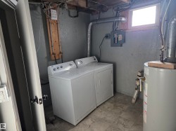 Washroom featuring gas water heater, separate washer and dryer, and electric panel - 