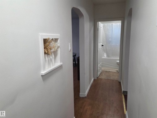 Hallway with arched walkways and dark wood-style flooring - 13023 Sherbrooke Avenue, Edmonton, AB - Indoor Photo Showing Other Room