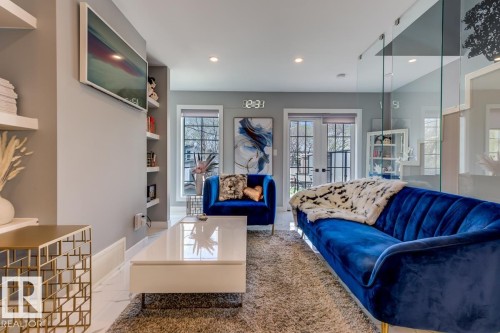 The living area features bright walls, recessed lighting, and a glass partition - 9526 109A Avenue, Edmonton, AB - Indoor