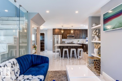 The property features an open-concept living area with a modern kitchen and a statement staircase - 9526 109A Avenue, Edmonton, AB - Indoor