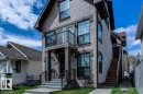 The property features a stone facade, a balcony with black railings, and an exterior staircase - 9526 109A Avenue, Edmonton, AB  - Outdoor With Facade 