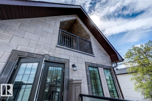 The property features a stone facade with dark framed windows and doors - 9526 109A Avenue, Edmonton, AB - Outdoor