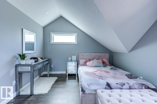 This room features sloped ceilings, hardwood flooring, and a rectangular window - 9526 109A Avenue, Edmonton, AB - Indoor Photo Showing Bedroom