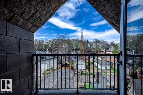 The property features a balcony with a black metal railing and views of the surrounding neighborhood - 9526 109A Avenue, Edmonton, AB - Outdoor With Exterior