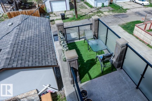 Outdoor patio area featuring artificial turf, a glass railing, and a decorative pillar - 9526 109A Avenue, Edmonton, AB - Outdoor With Exterior