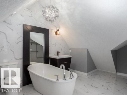 The bathroom features a freestanding bathtub, a vanity with a rectangular sink, and a toilet - 9526 109A Avenue, Edmonton, AB - Indoor Photo Showing Bathroom