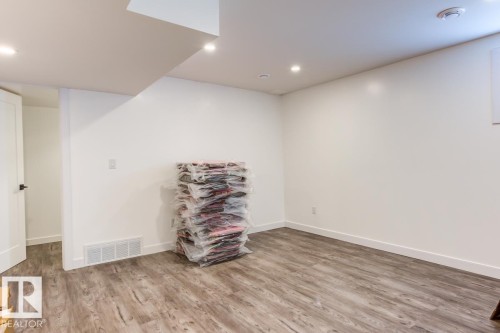 The property features light-colored walls, recessed lighting, and wood-look flooring - 9526 109A Avenue, Edmonton, AB - Indoor Photo Showing Other Room