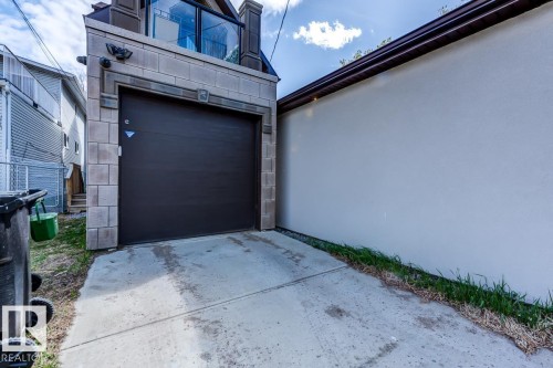 The property features a dark brown garage door with a concrete driveway - 9526 109A Avenue, Edmonton, AB - Outdoor