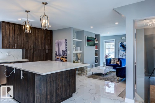 The kitchen features dark wood cabinetry, a light-colored island with a countertop, and recessed lighting - 9526 109A Avenue, Edmonton, AB - Indoor Photo Showing Kitchen