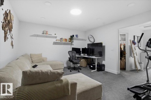 This versatile room features neutral-toned carpeting, recessed lighting, and wall-mounted shelving - 16624 32 Avenue, Edmonton, AB - Indoor Photo Showing Gym Room