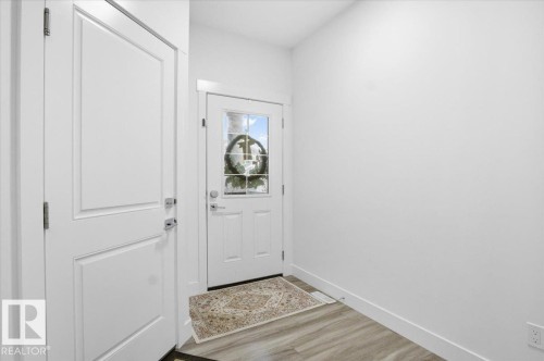 Welcoming entryway featuring a white paneled door, a white exterior door with a window, and light-colored flooring - 16624 32 Avenue, Edmonton, AB - Indoor Photo Showing Other Room