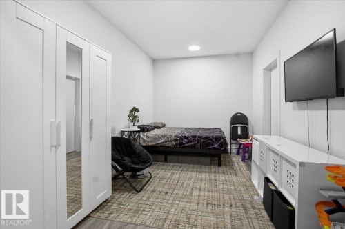 The property features a room with light-colored walls and a neutral-toned patterned rug - 16624 32 Avenue, Edmonton, AB - Indoor