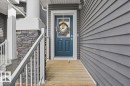 The property features a front entrance with a blue door, a wooden ramp, and stone accents on the porch column - 16624 32 Avenue, Edmonton, AB  - Outdoor With Exterior 