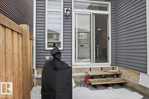 The property features gray horizontal siding and a light-colored wooden fence - 16624 32 Avenue, Edmonton, AB - Outdoor With Exterior