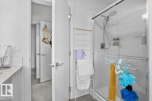 The bathroom features a glass-enclosed shower with a modern showerhead and a sleek vanity with a countertop - 16624 32 Avenue, Edmonton, AB - Indoor Photo Showing Bathroom