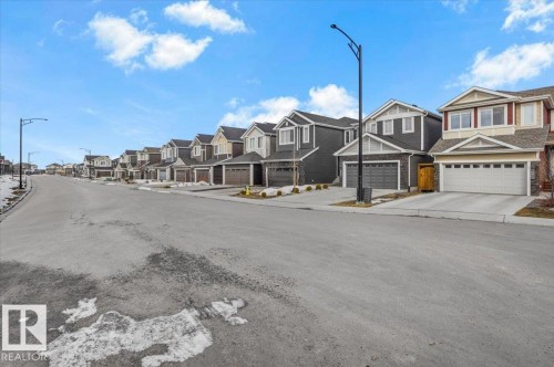 This property is located in a community featuring a paved street with streetlights and properties with attached garages - 16624 32 Avenue, Edmonton, AB - Outdoor With Facade