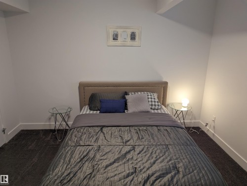 This bedroom features a neutral upholstered headboard and dark carpeting, providing a comfortable and inviting atmosphere - 16624 32 Avenue, Edmonton, AB - Indoor Photo Showing Bedroom