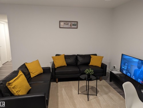 Living area featuring light gray walls, light flooring, and a neutral-toned area rug - 16624 32 Avenue, Edmonton, AB - Indoor Photo Showing Living Room
