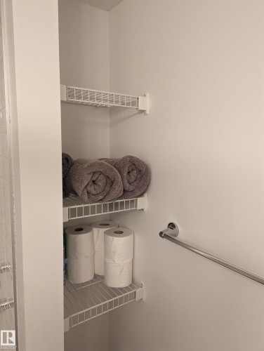 This storage area features white wire shelving and a chrome grab bar - 16624 32 Avenue, Edmonton, AB - Indoor With Storage