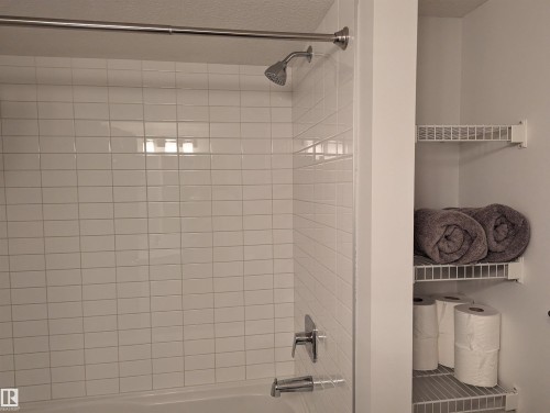The bathroom features a tiled shower with a chrome shower head and faucet - 16624 32 Avenue, Edmonton, AB - Indoor Photo Showing Bathroom