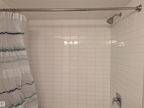 Shower featuring white subway tile surround, a chrome shower head, and a chrome single-handle faucet - 16624 32 Avenue, Edmonton, AB - Indoor Photo Showing Bathroom
