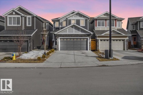 The property features a dark gray exterior with stone accents and a two-car garage - 16624 32 Avenue, Edmonton, AB - Outdoor With Facade