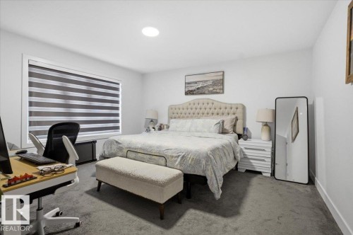 This room features soft grey carpeting, a large window with horizontal blinds, and a built-in ceiling light - 16624 32 Avenue, Edmonton, AB - Indoor Photo Showing Bedroom