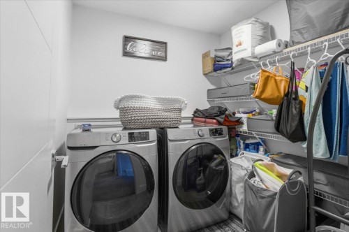 The laundry area features a washer and dryer, along with wall-mounted shelving for storage - 16624 32 Avenue, Edmonton, AB - Indoor Photo Showing Laundry Room