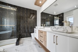 This bathroom features a double vanity with two vessel sinks, a large mirror, and a spacious shower with a glass enclosure - 